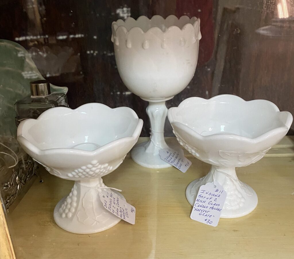 good quality, opaque milk glass in a glass case at an antique mall