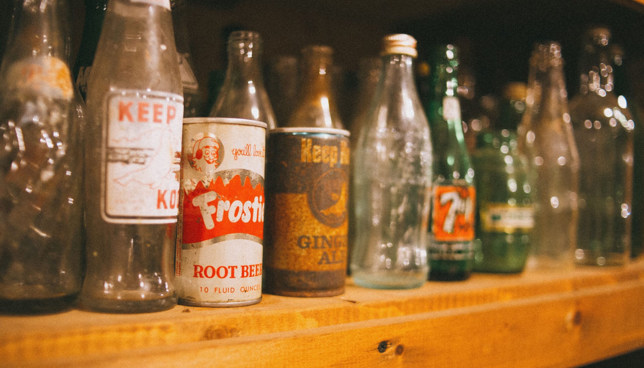 a line of old soda cans and bottles